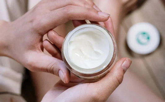 person holding an eye cream in hand